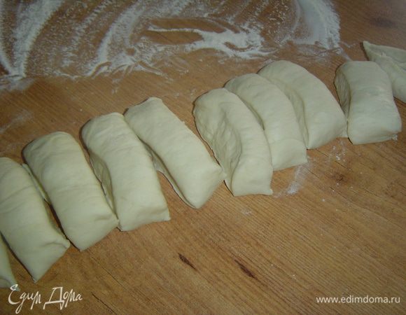 После того как тесто поднимется, обминаем его и делим на 10 равных частей.