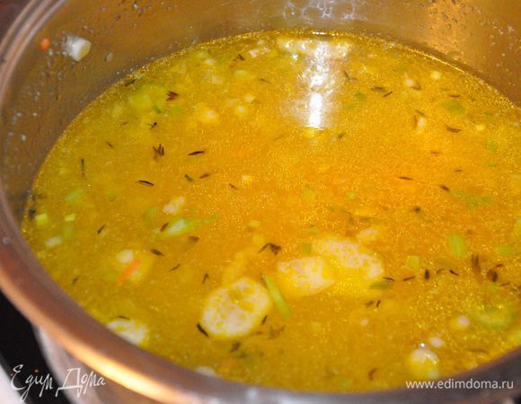 Добавьте тимьян, лавровый лист, тмин, соль, перец, и готовьте еще несколько минут. Всыпьте чечевицу, залейте все бульоном и варите все 20-25 минут. 
