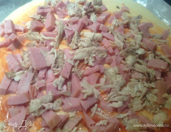 Курицу и ветчину нарезать кусочками и выложить на пиццу.