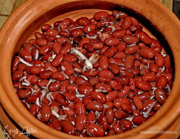 Горшочек смазать сливочным (оливковым маслом), фасоль (жидкость предварительно слить) перемешать с измельчённым чесноком, приправить зирой и солью.