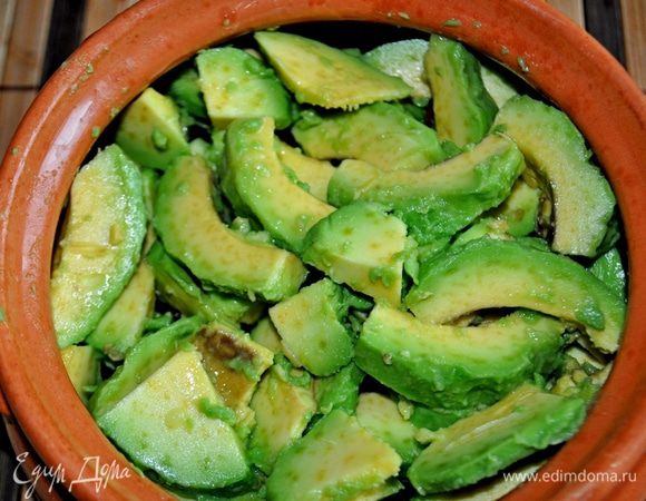 Авокадо очистить от кожуры и косточки, сбрызнуть лимонным соком, нарезать тонкими ломтиками.
В горшочек выложить фасоль со специями, сверху ломтики авокадо,
