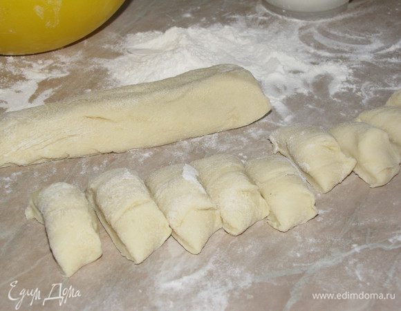 Затем формируем галушки. Тесто разделить на две части. каждую часть скатать в длинный брусок и нарезать кусочками.