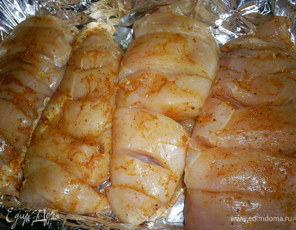 Натереть филе приправой для курицы, выложить филе в форму для запекания. Стеклянную или керамическую форму предварительно смазать сливочным или растительным маслом, обычную - застелить фольгой в два слоя.