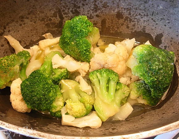 Затем засыпать цветную и брокколи, налить 100 мл. воды и тушить до готовности.