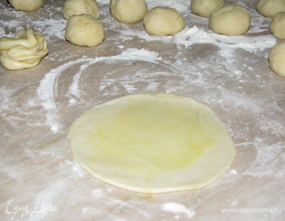 Шарик раскатать в лепешку толщиной 2-3 мм. Поверхность лепешки смазать оливковым маслом.