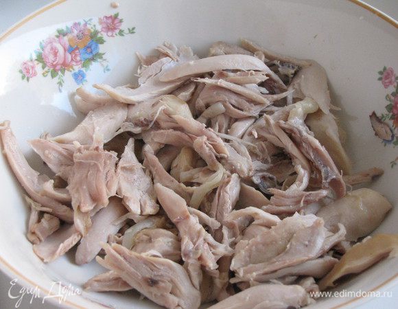 Если бульон к этому времени уже сварился, то можно вынуть курицу. Достать из бульона луковицу и морковку и выбросить. Курицу охладить и отделить мясо от костей. Мясо разделить на маленькие кусочки.
