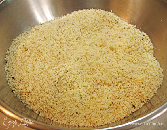  Блендером измельчаем бисквит в крошку, добавив миндальные лепестки. 