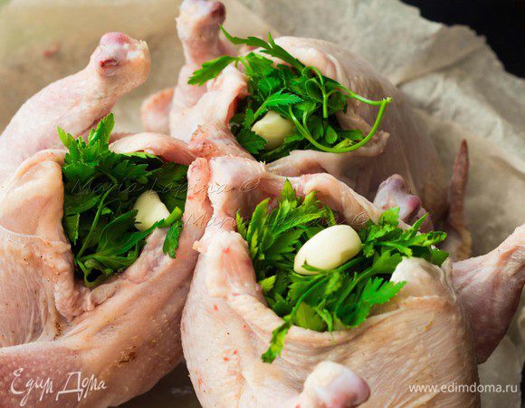 Цыплят хорошенько моем, обсушиваем бумажным полотенцем, натираем небольшим количеством соли изнутри и снаружи. Не забываем, что в маринаде у нас соевый соус, поэтому с солью не перебарщиваем. Пучок петрушки моем, разделаем на три равные части и кладем внутрь цыплят. Чеснок чистим и кладем по одной штуке в каждую птичку. 