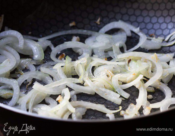 Пока курица готовиться подготовим для неё гарнир. Капусту нашинкуем тонкими полосками. Присолим её и пожмем пару минут в руках, так она станет мягче и даст сок. На сковороде разогреем оливковое масло и слегка обжарим лук, нарезав его полукольцами. 