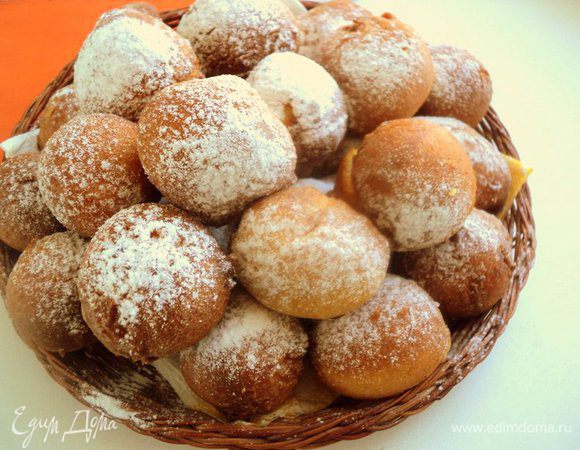 Переложите пончики на тарелку и посыпьте сахарной пудрой.