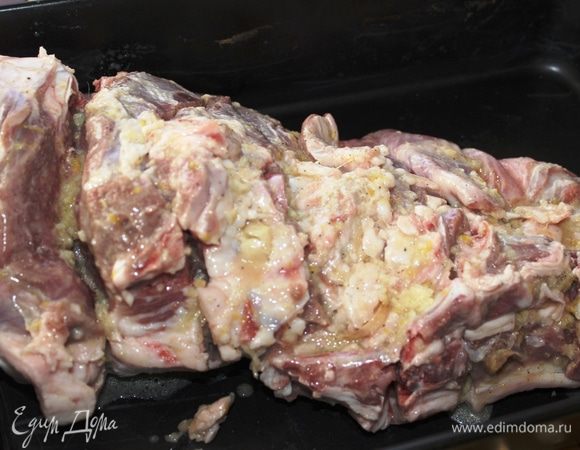 Ногу барашка разместить в глубокой жаропрочной форме, обмазать со всех сторон маринадом (постараться, чтобы он попал во все прорези), накрыть пленкой и оставить мариноваться в течение 2-3 часов.