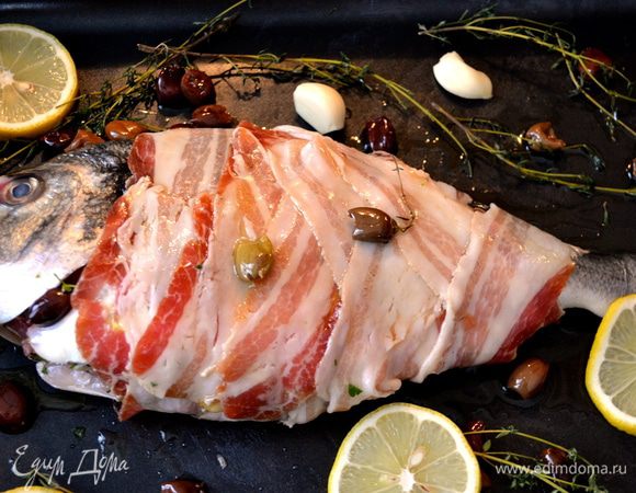 Выложить рыбу в форму для выпечке, соответствующую размеру Вашей дорады. Сбрызнуть рыбку оливковым маслом, посолить, добавить листья тимьяна и зубчики чеснока... Я от себя добавила немного мелких темных оливок (taggiascе). Можно выложить несколько долек лимона.