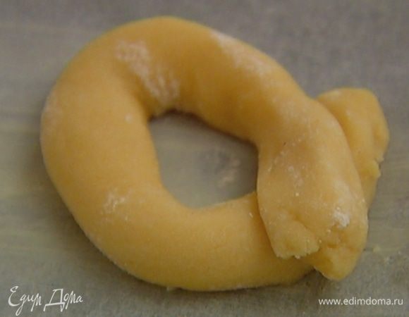 Тесто разделить на небольшие кусочки, сформировать из них колбаски и соединить кончики крест-накрест. 