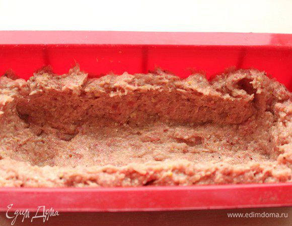 Перемешать куриный и говяжий фарши, добавить размоченные хлопья вместе с молоком, 2 ст.л. томатного соуса, горчицу, немного соли и перца. Хорошо вымесить руками. Выложить 2/3 фарша в прямоугольную форму для запекания и сформировать бортики.