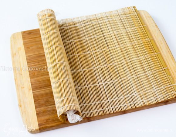 С той же длинной стороны коржа скатайте рулет снова, но уже без полотенца. Чтобы рулет не рвался можно заворачивать с помощью пергамента. Для того, чтоб рулет у меня был круглый, а не приплющенный снизу, я завернула его в коврик для сворачивания суши и убрала в холодильник до использования.