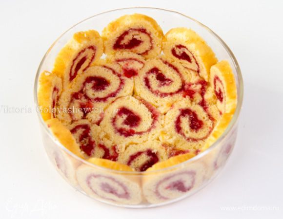 Выложите дно большой сервировочной миски ломтиками рулета, сбрызните их 2–3 ст. л. ликера.