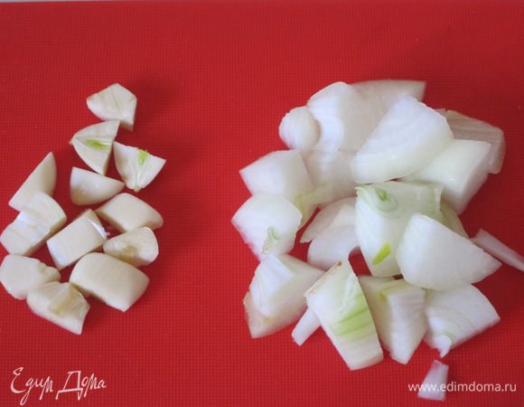 Заранее, за 12 часов, замочить нут в большом количестве воды. За это время можно 1-2 раза поменять воду. Откинуть на дуршлаг. Лук и 3 дольки чеснока очистить и нарезать.