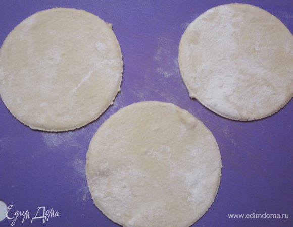Отделить от теста шарики размером с крупное яйцо. Раскатать в кружки толщиной 3-4 мм.  Вырезать кружки блюдцем.