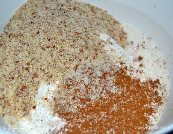 В миске смешать муку, сахар, разрыхлитель и корицу.Добавить орехи,предварительно измельчив их до нужного вам состояния.Я измельчила более мелко.