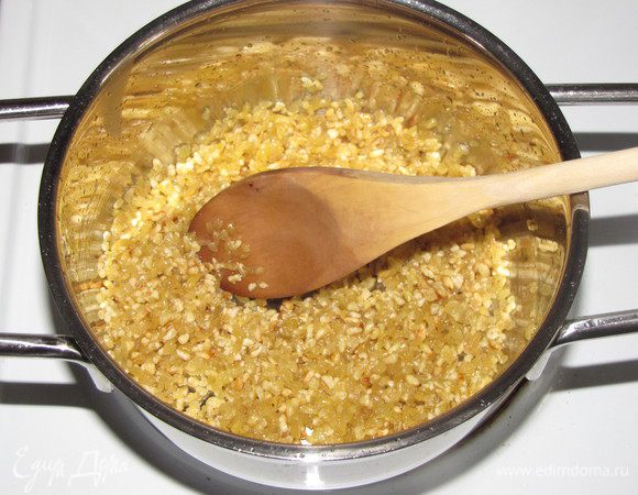 Разогреть в сотейнике 1 ст. л. оливкового масла, всыпать булгур и немного обжарить, помешивая. Влить воду, так, чтобы покрыть крупу. Посолить, поперчить, закрыть крышкой и готовить на медленном огне 25 минут.