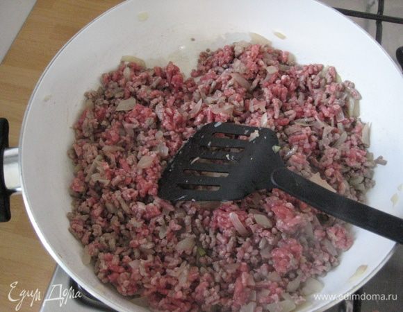 Добавить фарш, помешивая, дать выпариться жидкости, постоянно мешая, чтоб не было комочков, добавить красное вино, выпарить (примерно 5 минут).