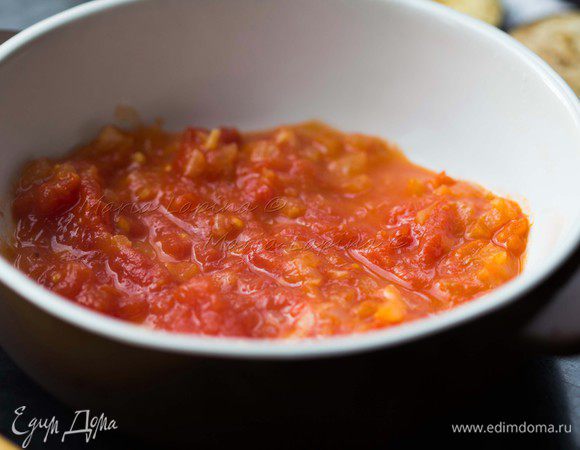 На дно формы положить и распределить пару ложек соуса.