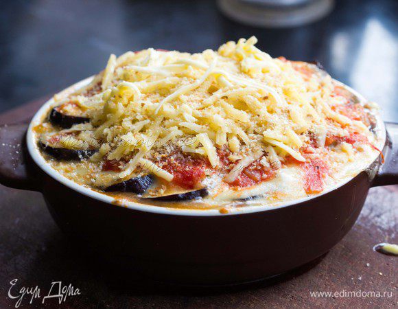 Достать форму, посыпать еще пармезаном и панировочными сухарями. Сверху положить немного тонко нарезанного сливочного масла. Отправить в духовку на 10 минут.