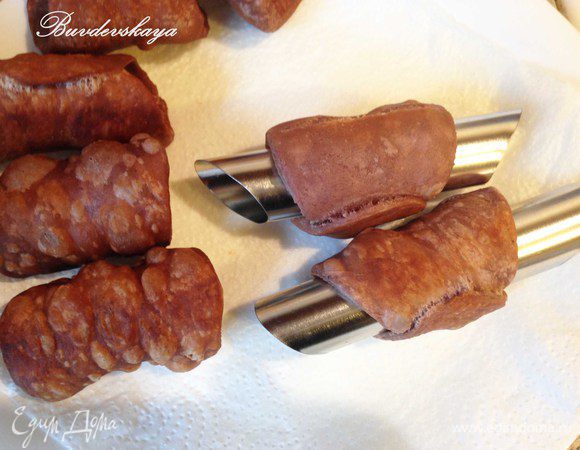 Нагреть масло в кастрюле и обжаривать трубочки до золотистого цвета. Достать трубочки из масла и выложить на бумажное полотенце, чтобы впиталось лишнее масло. Затем аккуратно достать металлическую трубочку, придерживая канноли с помощью салфетки, чтобы не обжечься.