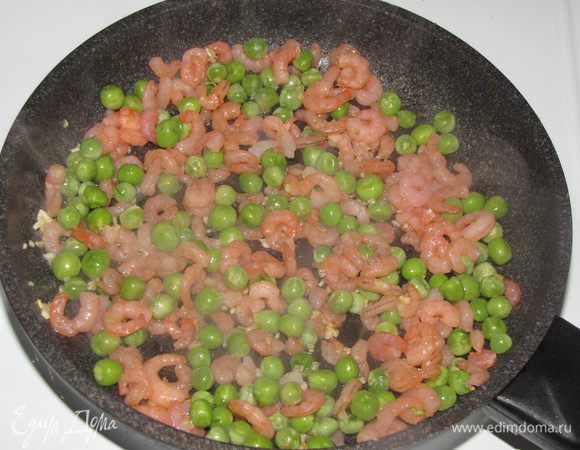 Добавить креветки и жарить 5 минут. Затем добавить зеленый горошек , жарить еще 5 минут.