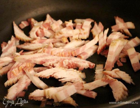 Для начинки мелко нарезать лук, грибы и бекон. Растопить бекон на горячей сковороде и выложить его на тарелку. 