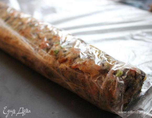 На доску натянуть пищевую плёнку. Выложить на плёнку начинку и сформировать колбаску, на 2-3 см меньшую, чем длина куска мяса. Завернуть колбаску в плёнку и убрать в морозильник на ночь.