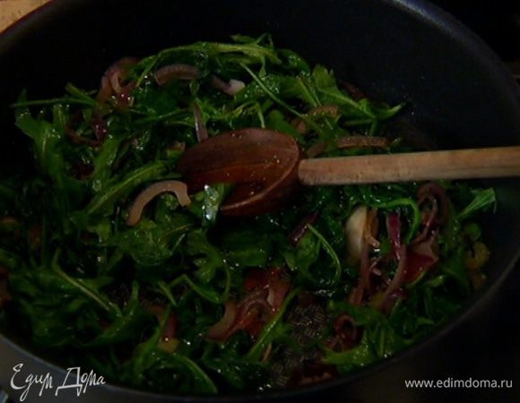 Выложить в сковороду с овощами руколу, все перемешать и немного прогреть. Присыпать мускатным орехом, еще раз перемешать и снять с огня. 