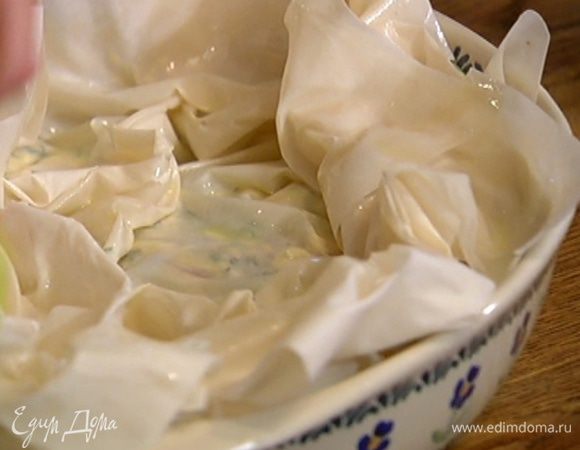 Последний лист фило смазать маслом и выложить сверху на начинку, слегка скомкав края, промазать маслом все свешивающиеся края теста и завернуть их на пирог, тоже немного скомкав.