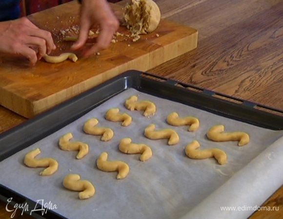 Противень выстелить бумагой для выпечки, смазать ее оставшимся сливочным маслом и выложить печенье.