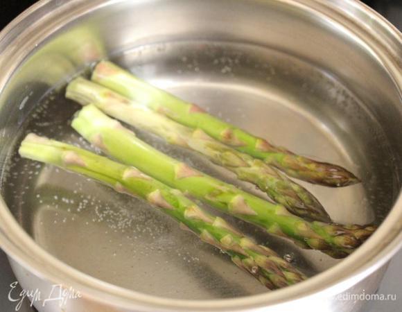 У спаржи отрезать-отломить подсохшие кончики и отварить её в подсоленной воде. Затем опустить побеги на 5 минут в ледяную воду.