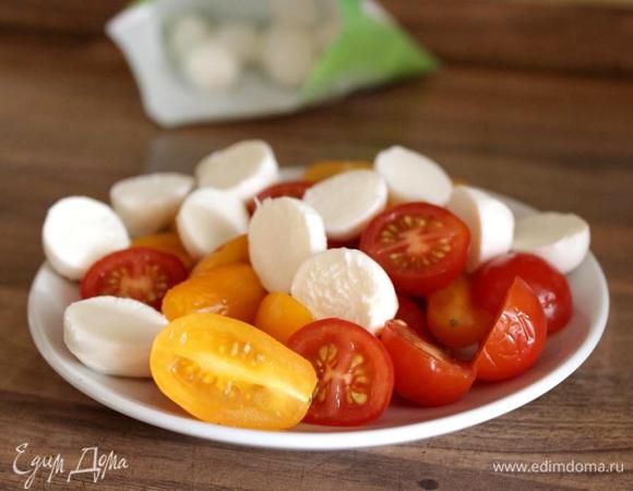 Помидоры и моцареллу разрезать пополам, листики базилика свернуть в трубочку и нарезать ленточками. Все овощи и сыр промокнуть бумажным полотенцем.