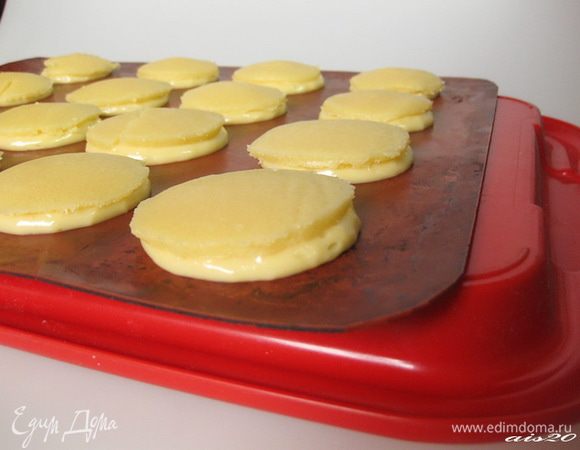 Из замороженного крамбла вырезать кружки такого же размера, как отсаженные на подносе профитроли.
Сверху каждой профитроли выложить кружочек крамбла.
Профитроли убрать в морозильную камеру до полной заморозки (около 1 часа).