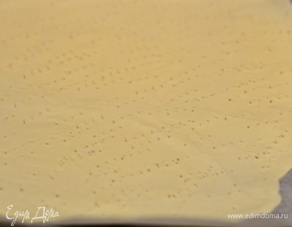 Раскатайте тесто на пергаменте  ооочень тонко,как вы можете,наколите его везде вилкой и 