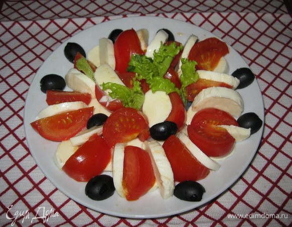 Выложите сыр вперемешку с помидорами на 4 индивидуальные тарелки. Посолите и поперчите по вкусу. Смешайте оливковое масло с соусом песто и полейте этой смесью сверху каждой тарелки.
 Украсьте маслинами, базиликом (у меня листья салата) и подавайте на стол.