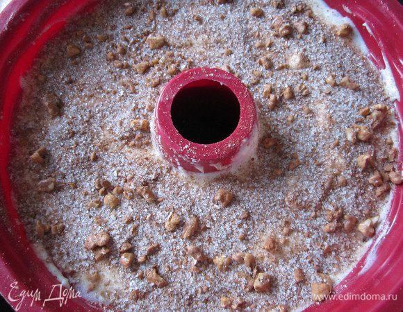 Форму для кекса смазать сливочным маслом. В форму выложить половину теста и разровнять. Выложить на тесто 3/4 ореховой начинки. Сверху – оставшееся тесто и присыпать его оставшейся ореховой начинкой. 