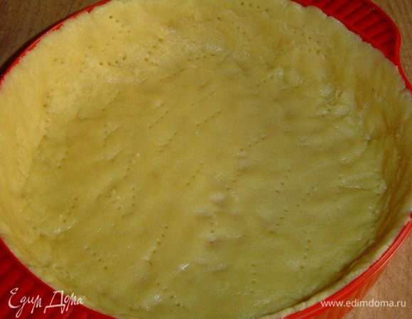 Крем остывает, а мы достаем тесто из холодильника, кладем его в подготовленную форму и руками распределяем по форме и также формируем бортики. Тесто накалываем вилкой,