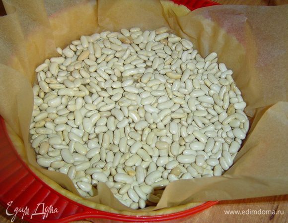 сверху застилаем пергаментной бумагой, на нее высыпаем фасоль или горох, и отправляем в духовку, разогретую до 200 гр. на 10 минут. Затем температуры снижаем до 180 гр., вынимаем форму, убираем пергаментную бумагу с грузом и опять ставим форму в духовку на 10 минут.