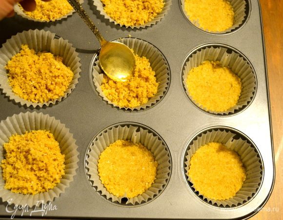 Формочки для маленьких кексиков заполнить бумажными стаканчиками и выложить в них по столовой ложке полученной смеси. Утрамбовать с помощью маленькой ложечки. Убрать в холодильник на 30 мин.