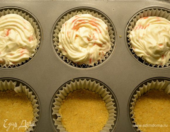 Достать форму с нашими заготовками для чизкейков. Выложить на печенье сырную начинку с помощью кулинарного мешка. Но, можно и просто аккуратно ложкой...