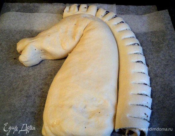 Противень застелить бумагой для выпечки. Из рулета с яблоками и тыквой сформировать голову лошади. Рулет с маком выложить вдоль головы вплотную к первому рулету и надрезать на кусочки толщиной 1–1.5 см.