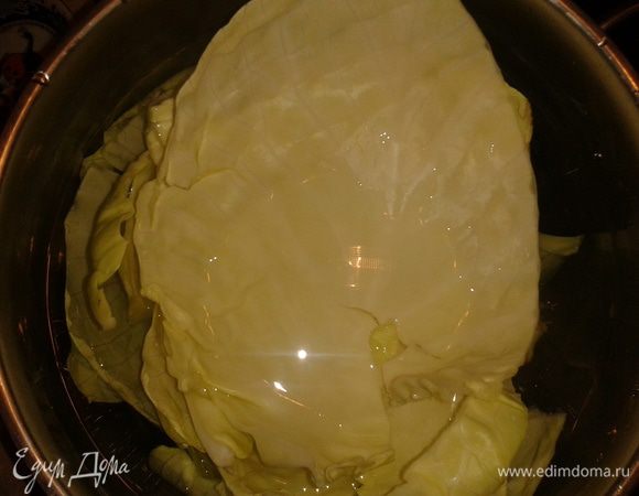 Налить в кастрюлю воду и положить листья капусты.