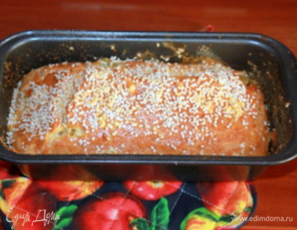 Заполните получившимся тестом форму, сверху посыпьте кунжутом и запекайте в горячей духовке примерно 35-40 минут. Готовому кексу дайте остыть прямо в форме 10-15 минут, затем, перевернув ее, переложите кекс на блюдо.   
