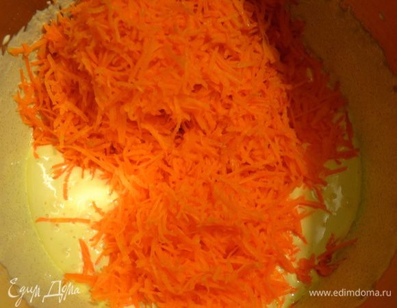 Далее по очереди добавлять остальные ингредиенты в следующем порядке. Сначала в яичную смесь добавить морковь, тертую на мелкой терке.  