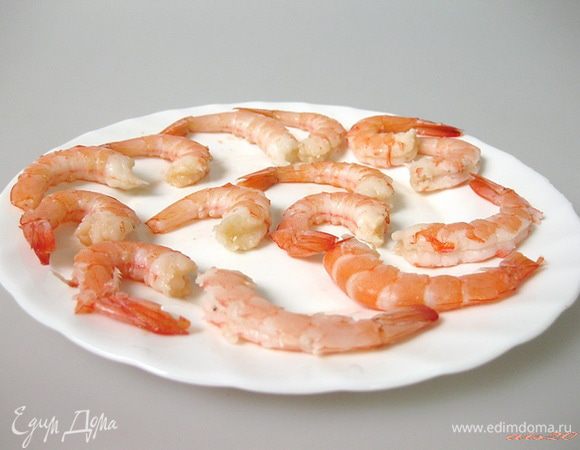 Замороженные вареные креветки разморозить, ошпарить кипятком и очистить от панциря и голов, оставив хвостики.