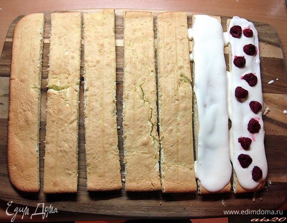 Остывший корж нарезать на полосы шириной 5 см.
Каждую полосу щедро смазать кремом, сверху выложить малину.